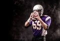 American football player holding ball in his hands in smoke. Black background, copy space. The concept of American Royalty Free Stock Photo