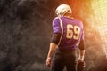 American football player holding ball in his hands in smoke. Black background, copy space. The concept of American Royalty Free Stock Photo