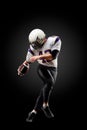 American football player in a jump with a ball on a black background Royalty Free Stock Photo