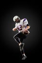American football player in a jump with a ball on a black background Royalty Free Stock Photo