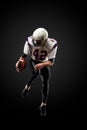 American football player in a jump with a ball on a black background Royalty Free Stock Photo