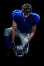 American football player looking down while holding helmet Royalty Free Stock Photo