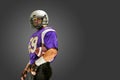 American football player posing with ball on black background Royalty Free Stock Photo