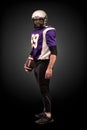 American football player posing with ball on black background Royalty Free Stock Photo