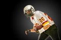 American football player posing with ball on black background. Super Bowl concept. Concept American football, portrait Royalty Free Stock Photo