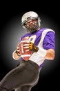 American football player posing with ball on black background. Super Bowl concept. Concept American football, portrait Royalty Free Stock Photo