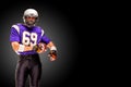 American football player posing with ball on black background. Super Bowl concept. Concept American football, portrait Royalty Free Stock Photo