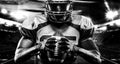 American football player, athlete in helmet with ball on stadium. Black and white photo. Sport wallpaper with copyspace. Royalty Free Stock Photo