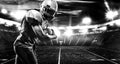 American football player, athlete in helmet with ball on stadium. Black and white photo. Sport wallpaper with copyspace. Royalty Free Stock Photo