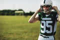 American football player strapping on his helmet during practice Royalty Free Stock Photo