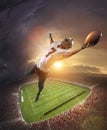 American football players catching ball in flight overt stadium with flashlights at evening time. Concept of sport Royalty Free Stock Photo