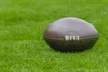 American football, rugby ball on green grass field background Royalty Free Stock Photo