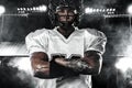 Sports betting on American football. Sportsman with ball in helmet on stadium. Bets in the mobile application.. Sport wallpaper. Royalty Free Stock Photo