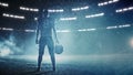 American Football Staduim: Lonely Athlete Warrior Standing on a Field Holds his Helmet and Ready to Royalty Free Stock Photo