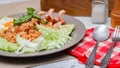 American fried rice served with sausages, cucumbers, shredded vegetables in a gray plate on a white table with seasoning Royalty Free Stock Photo