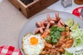 American fried rice served with sausages, cucumbers, shredded vegetables in a gray plate on a white table with seasoning Royalty Free Stock Photo