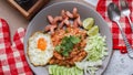 American fried rice served with sausages, cucumbers, shredded vegetables in a gray plate on a white table with seasoning Royalty Free Stock Photo