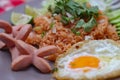 American fried rice served with sausages, cucumbers, shredded vegetables in a gray plate on a white table with seasoning Royalty Free Stock Photo