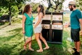 American friends having a backyard barbecue party, laughing and smiling while cooking