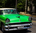 American green classic car on the road in havana