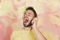 American handsome bearded guy with headphones. Blue eyed stylish hipster with smartphone. Cheerful teenage dj listening Royalty Free Stock Photo