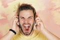 American handsome bearded guy with headphones. Cheerful teenage dj listening songs via earphones. Blue eyed stylish Royalty Free Stock Photo