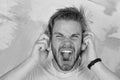 American handsome bearded guy with headphones. Cheerful teenage dj listening songs via earphones. Blue eyed stylish Royalty Free Stock Photo