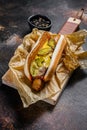 American hot dog with pork sausage on a wooden cutting Board in Kraft paper, fast food restaurant menu concept. Junk Royalty Free Stock Photo