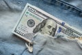 American hundred dollars sticking out of a hole in jeans close up Royalty Free Stock Photo