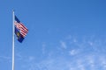 American and Indiana flags flying from tall flagpole against blue sky with whispy clouds - Room for copy
