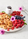 American mini pancake board with berries and maple syrup