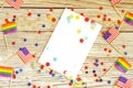 American mini and Pride Flags lie on a wooden background, top view, template for invitations and posters. Acceptance symbol. space