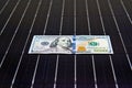 American money on solar panel surface. Renewable energy cost Royalty Free Stock Photo