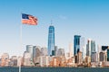 American national flag on sunny day with New York city Manhattan island in background. United States nation symbol concept Royalty Free Stock Photo