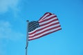 Flag of USA waving in wind on blue sky background Royalty Free Stock Photo