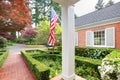 American old brick home with flag and classic garden. Royalty Free Stock Photo