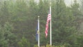 American And Oregon State Flag Flying Limply In Pouring Rain