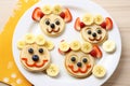 American pancakes decorated like smile and happy faces with strawberries, chocolate, blueberries and banana. Food for kids,