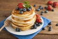 American pancakes or fritters served with strawberry and blueberry jam, delicious dessert for breakfast, rustic style, wooden back Royalty Free Stock Photo