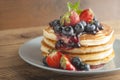 American pancakes or fritters served with strawberry and blueberry jam, delicious dessert for breakfast, rustic style, wooden back Royalty Free Stock Photo