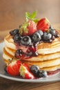 American pancakes or fritters served with strawberry and blueberry jam, delicious dessert for breakfast, rustic style, wooden back Royalty Free Stock Photo