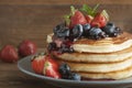 American pancakes or fritters served with strawberry and blueberry jam, delicious dessert for breakfast, rustic style, wooden back Royalty Free Stock Photo