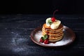 American pancakes on a plate with banana, cherry and mint