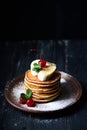 American pancakes on a plate with banana, cherry and mint