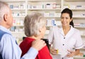 American pharmacist dispensing to senior couple Royalty Free Stock Photo