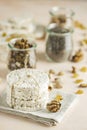 American puffed rice cakes. Healthy snacks with almonds, raisins, peanuts, pistachios in glass jars on light pink concrete surface Royalty Free Stock Photo