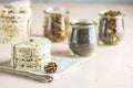 American puffed rice cakes. Healthy snacks with almonds, raisins, peanuts, pistachios in glass jars on light pink concrete surface Royalty Free Stock Photo