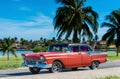 American red Ford classic car with black roof parked under blue sky near the beach in Havana Cuba - Serie Cuba Reportage