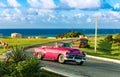American red pink 1954 convertible vintage car on the fortress el Morro near the beach in Havana Cuba - Serie Cuba Reportage