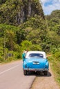 American retro car on the road, Vinales, Pinar del Rio, Cuba. Copy space for text. Vertical.